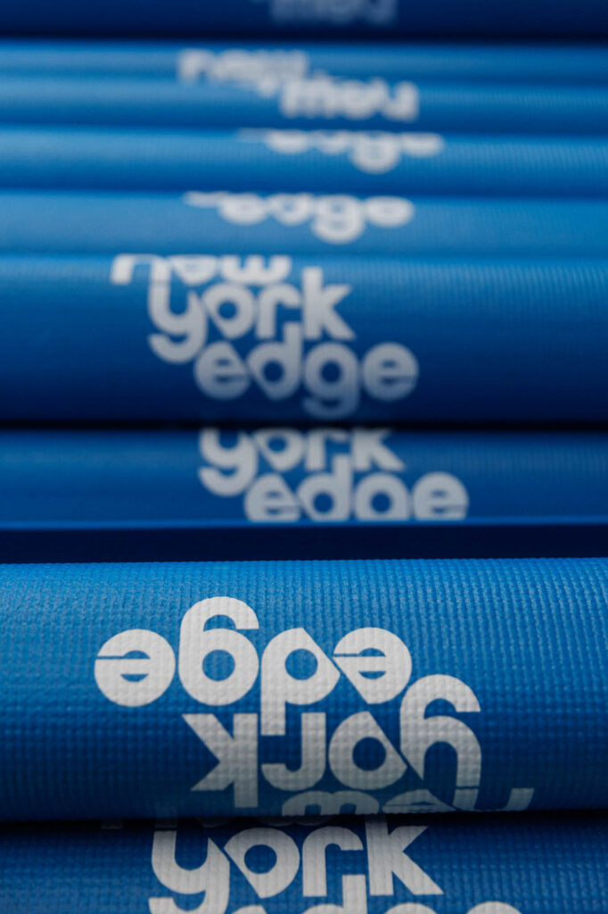 Blue yoga mats branded with the New York Edge's logo used on the wellness sessions.